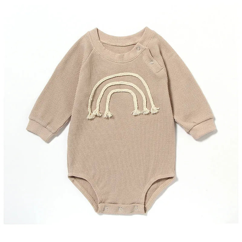 Infant wearing a beige waffle cotton long sleeve romper climbing suit