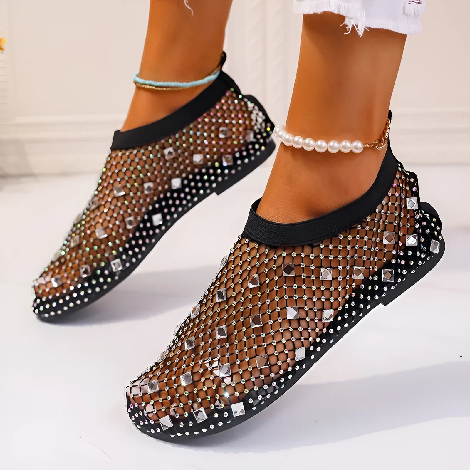 Women's flat sandals with a colourful rhinestone design on a breathable mesh upper and a rubber sole.