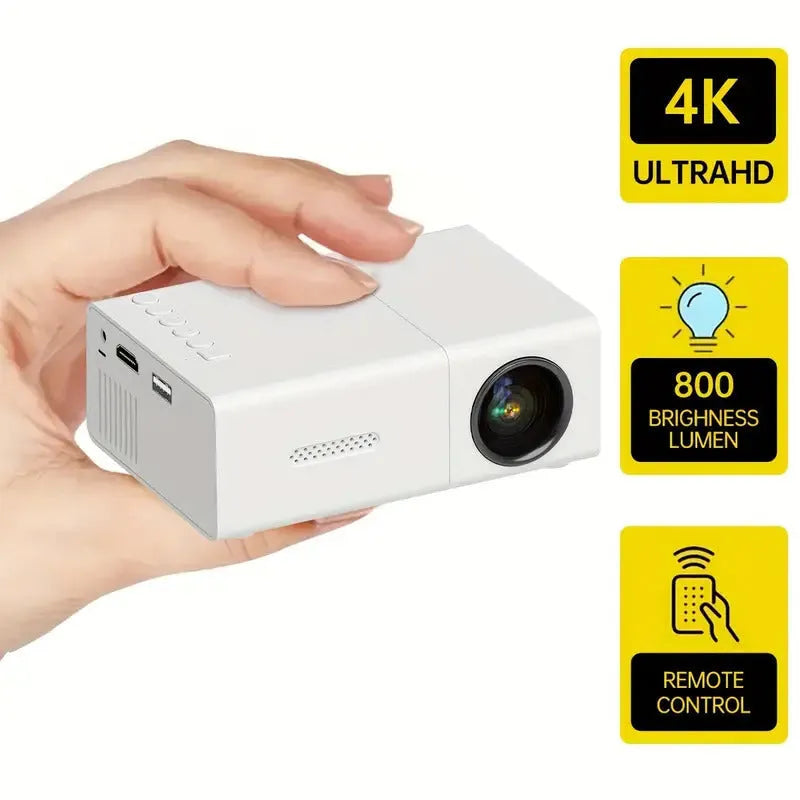 Compact white M100 mini LED home projector with remote control on a table.