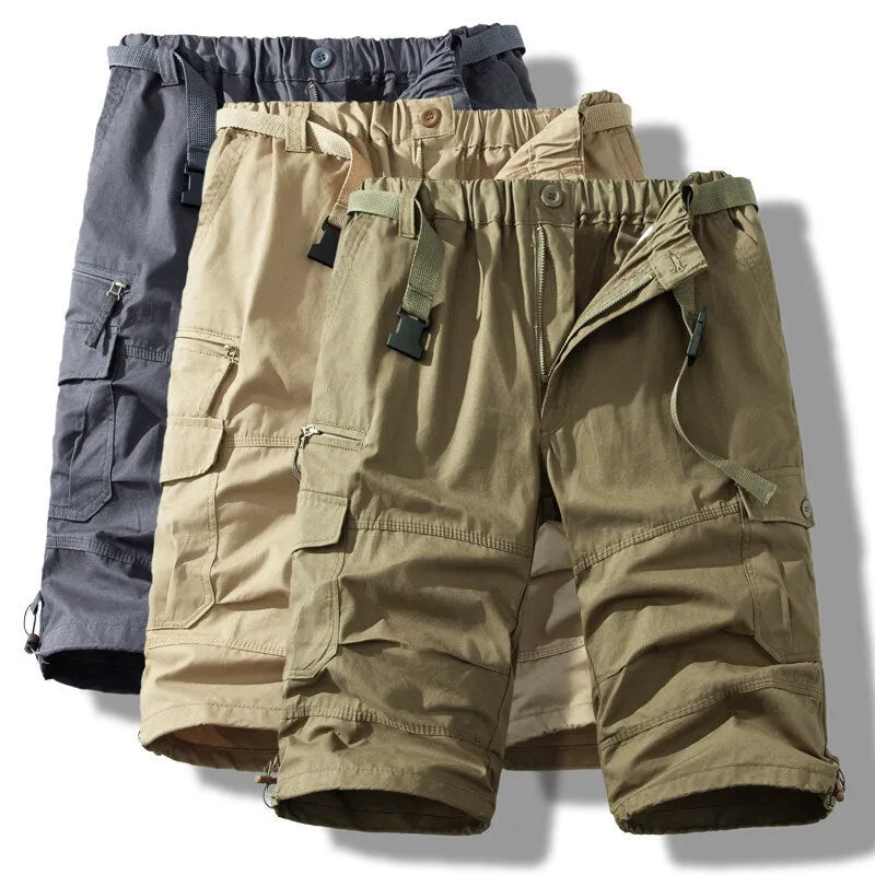 Men's cotton cropped overalls in army green, shown in a casual summer setting.