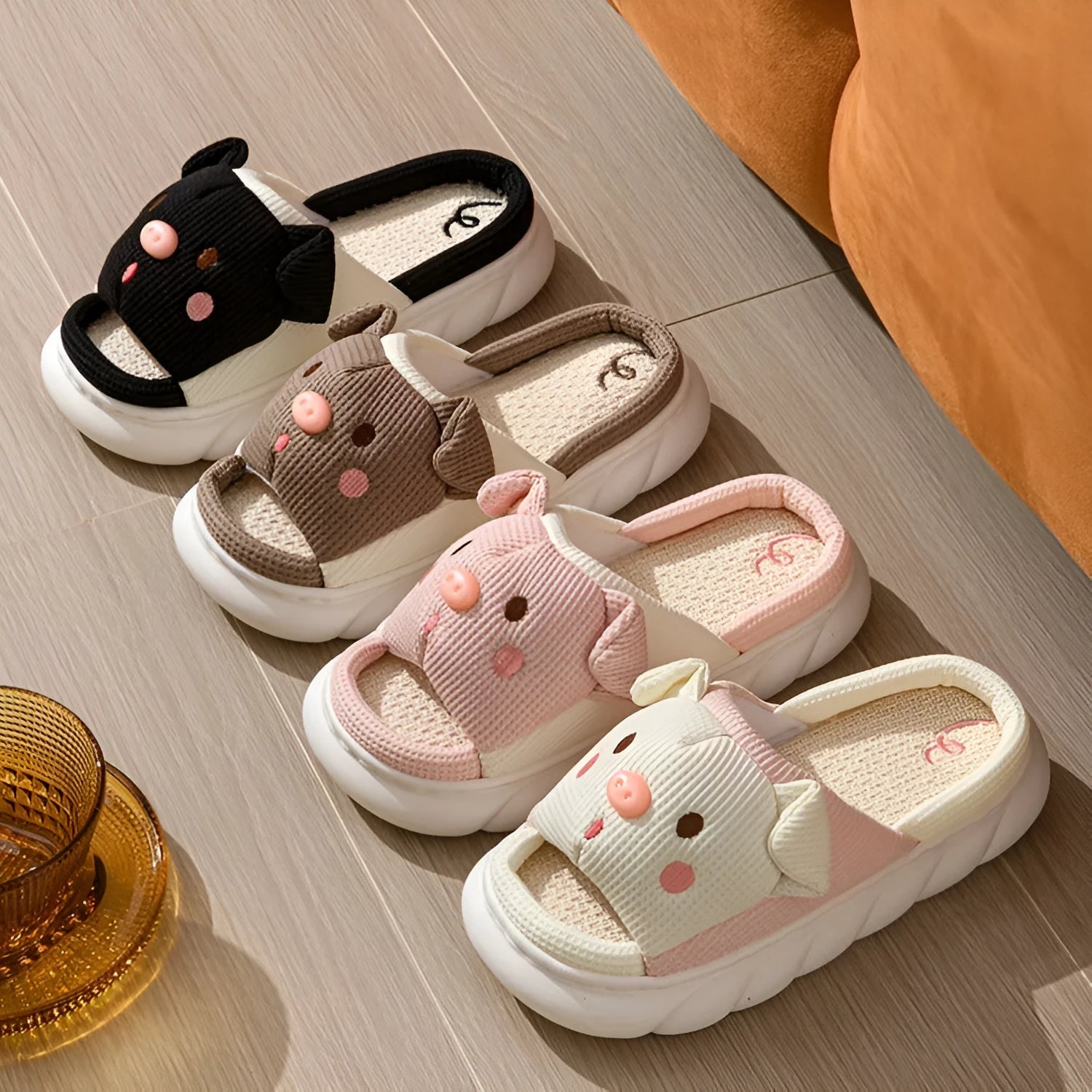 A pair of Piggy Cute linen couple slippers in open toe flip flop style on a plain background.