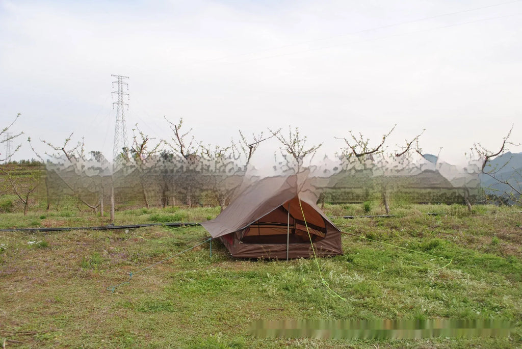 Brown A-Line pole-free cabin tent set up in a forest, showing its spacious interior for 2-3 people.
