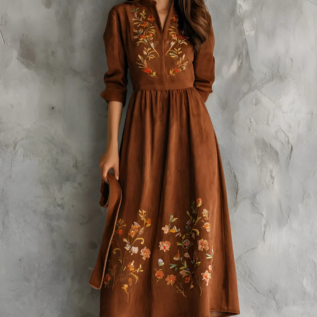 Brown suede-effect midi dress with detailed floral embroidery on the skirt, shown on a model.