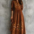 Brown suede-effect midi dress with detailed floral embroidery on the skirt, shown on a model.
