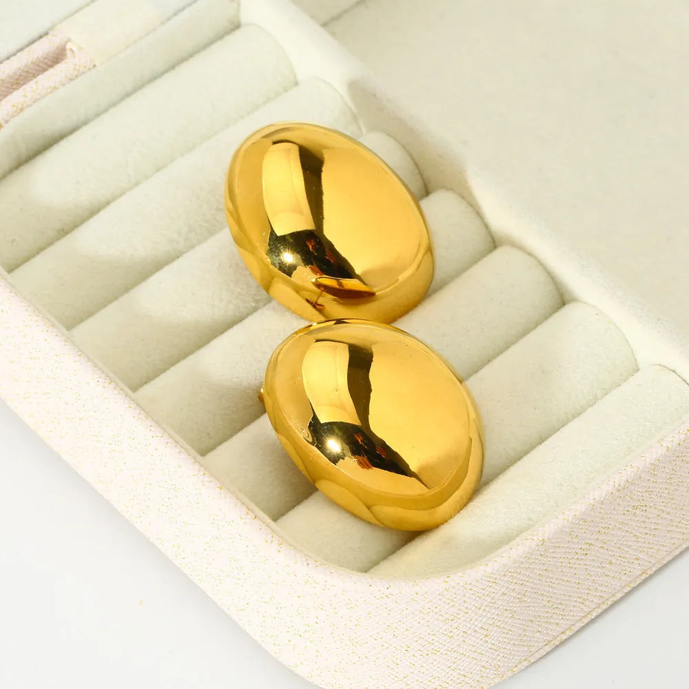 Geometric gold-coloured ear studs with glazed surface and line design details