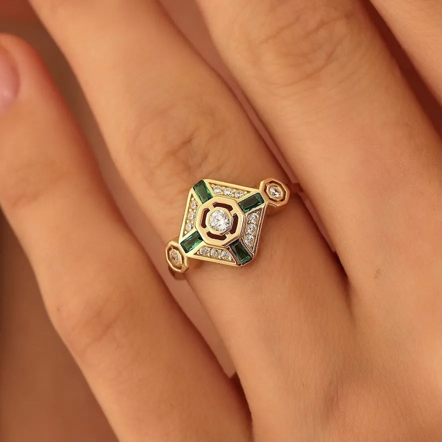 Square emerald-coloured gemstone ring for women on a plain background.