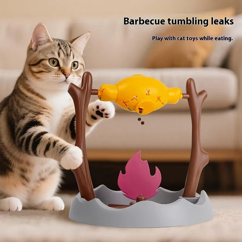 Barbecue-themed tumbling cat food feeder toy with treat dispenser, shown next to dry kibble.