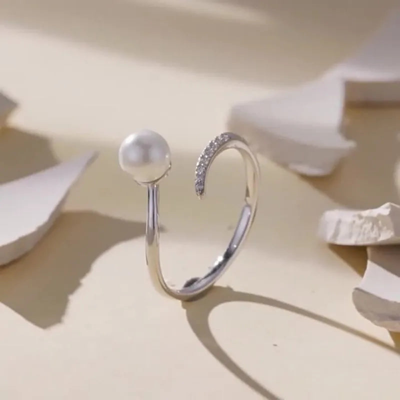 Adjustable open-loop sterling silver ring featuring a genuine shell pearl.