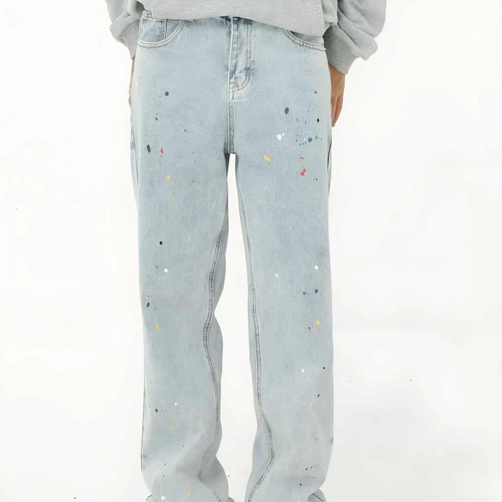 Light blue straight loose jeans with paint splash and washed finish, mid-waist zip fly, laid flat on neutral background