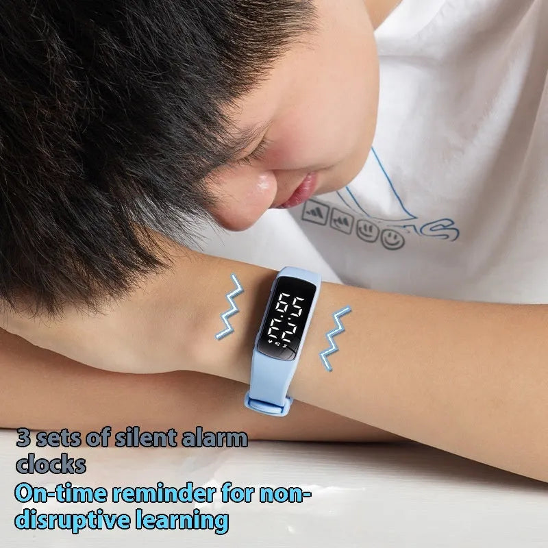 Black electronic digital watch with LED display and silicone strap on a wrist.