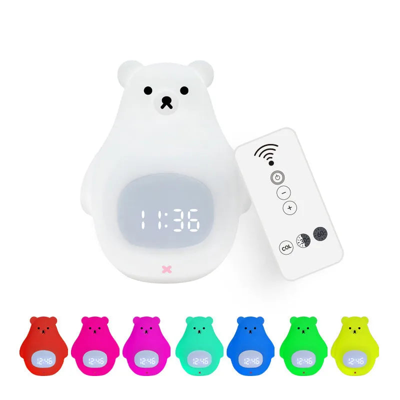 White silicone bear-shaped night light with remote control on a wooden bedside table.