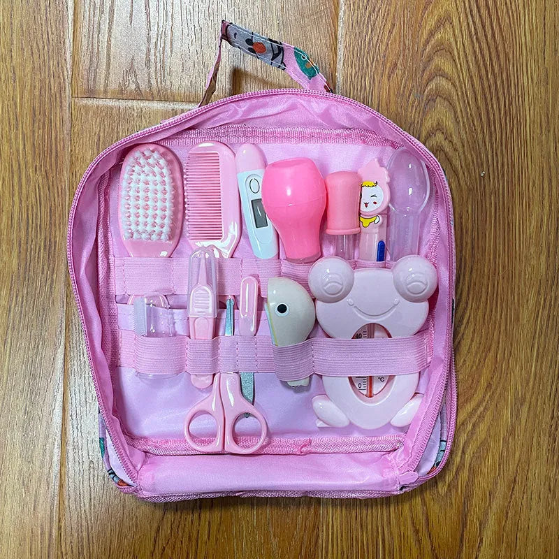 Roadfisher Newborn Baby Care Kit in pink or blue, showing safety scissors, brush, comb, thermometer, and syringe.
