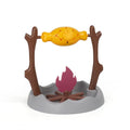 Barbecue-themed tumbling cat food feeder toy with treat dispenser, shown next to dry kibble.