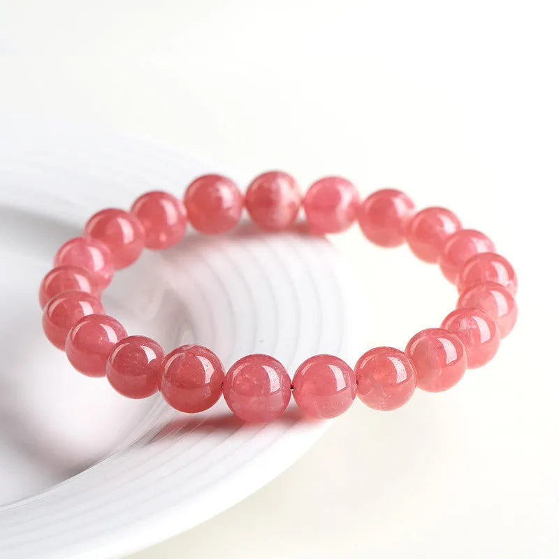 Close-up of a red rhodochrosite crystal bracelet with geometric beads and a Longevity Lock clasp.