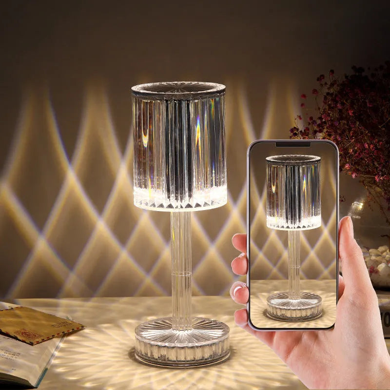 Modern crystal table lamp with transparent bead shade and metal stand on wooden surface