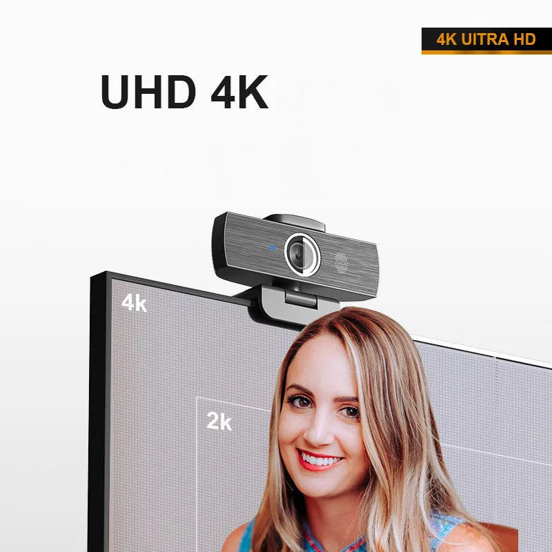 Black 4K USB webcam with attached cable and a magnetic privacy cover on a desk.