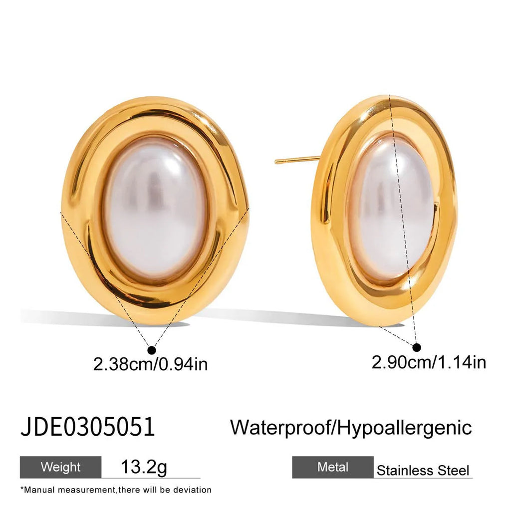 A pair of small stainless steel ear studs with a vintage-style pearl decoration on a silver-coloured base.