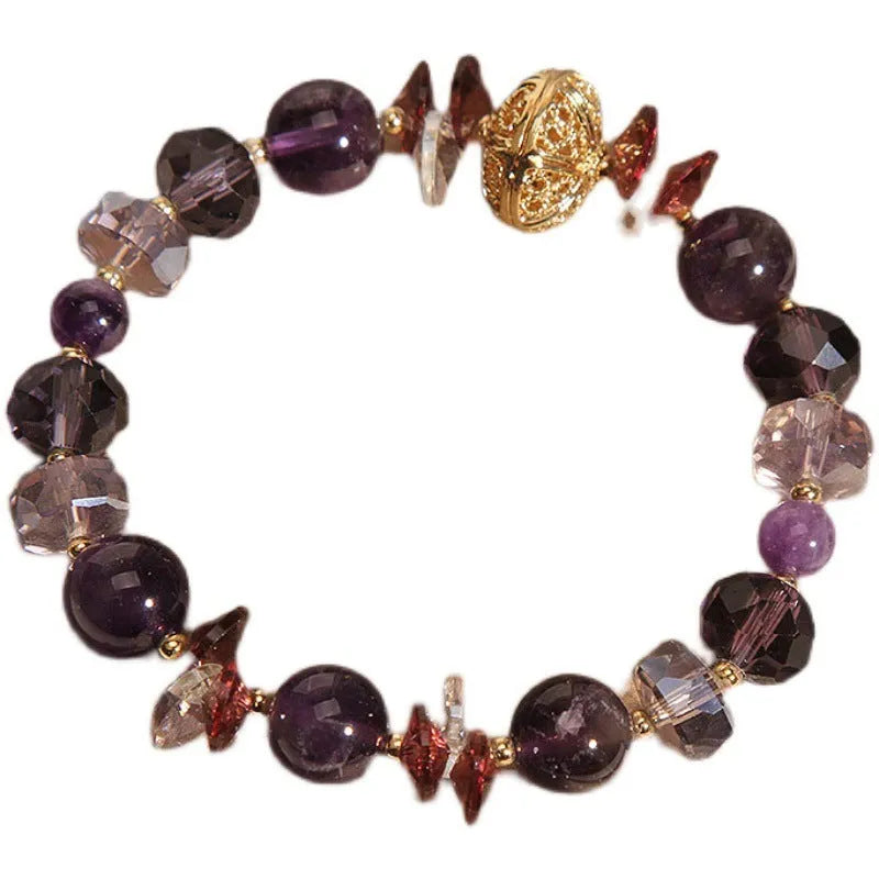 Purple crystal bracelet with pumpkin beads and rhinestone decoration on a wrist.