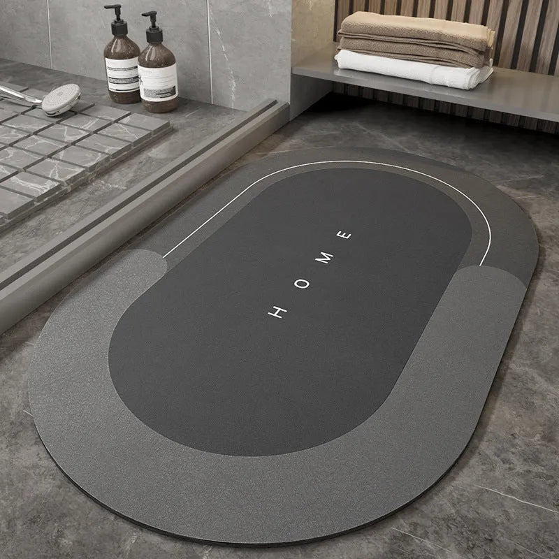 Machine woven bathroom floor mat in blue colour, shown in an oval shape on a tiled floor.