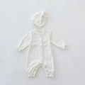 Beige knitted cotton baby jumpsuit with wooden ear collar and lace, long sleeves, hood, on a neutral background