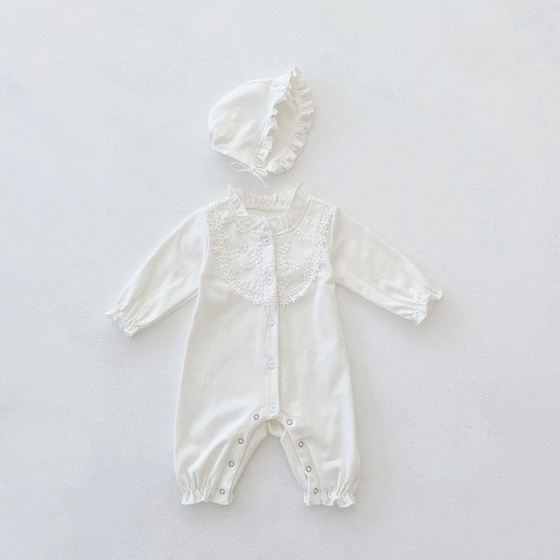 Beige knitted cotton baby jumpsuit with wooden ear collar and lace, long sleeves, hood, on a neutral background