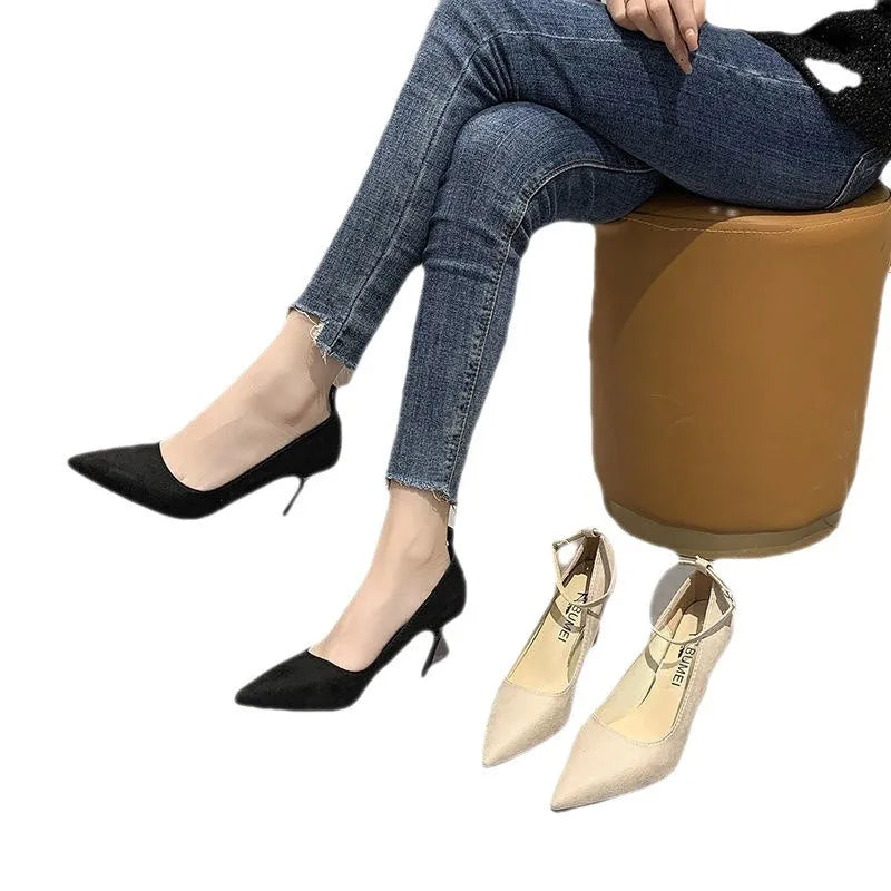 Women's black stiletto pumps with skull pattern and buckle detail on rubber sole