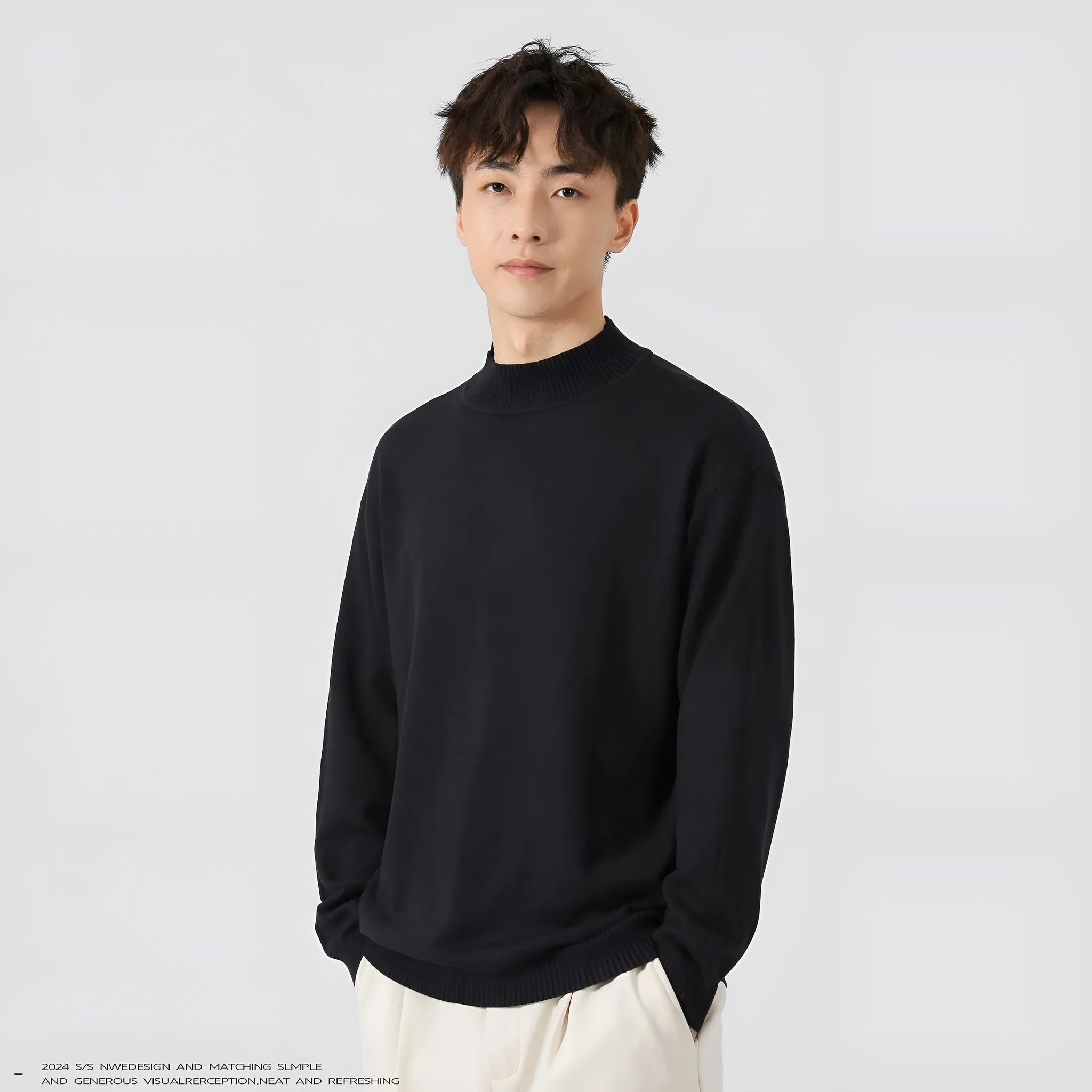 Man wearing a loose-fit long-sleeve solid colour sweater in a casual setting.