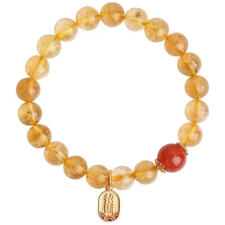 Natural red agate bead bracelet with gold-coloured spacers on a wrist.