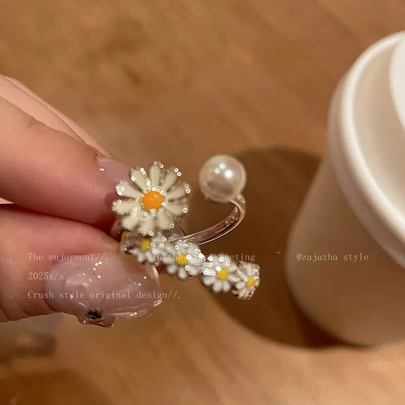 Women's adjustable copper ring with a little daisy and pearl decoration on a white background.
