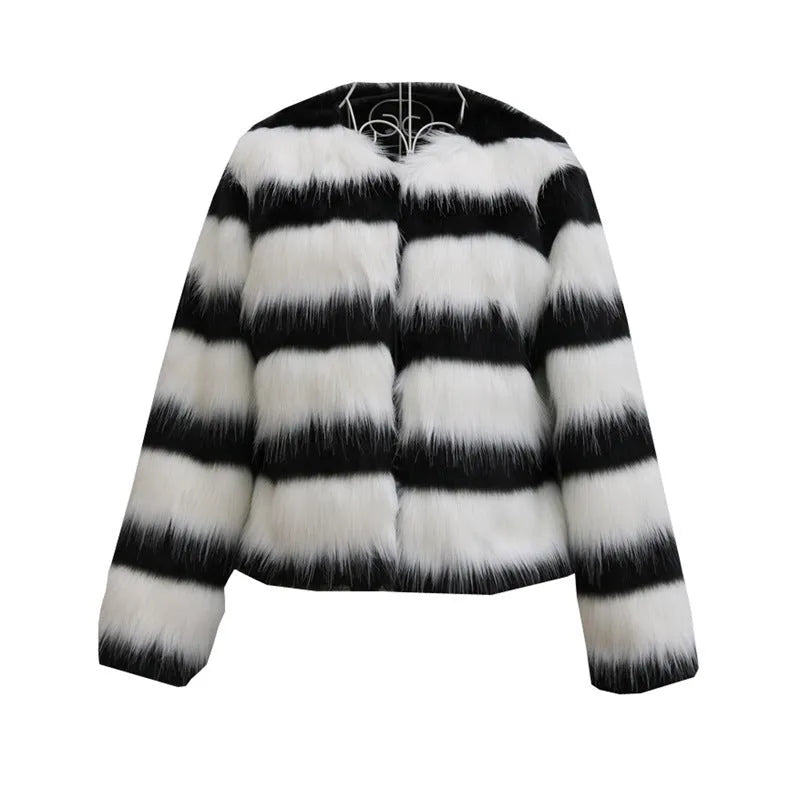 Long-sleeved black and white striped faux fur jacket for women on a grey background.