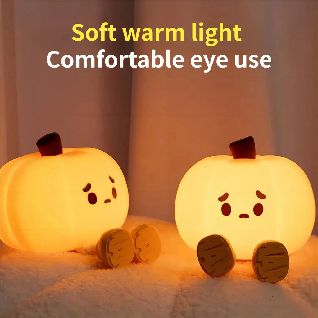Soft orange silicone pumpkin-shaped night light with a gentle glow, sitting on a surface.