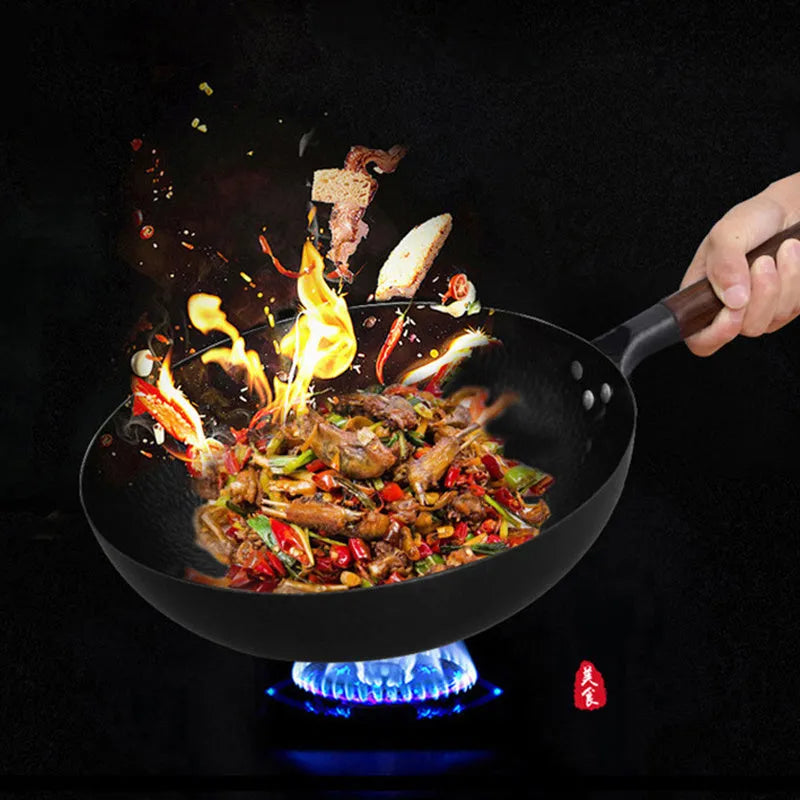 Black handmade traditional iron wok with a long wooden handle, shown with a glass lid.