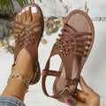 Black Roman style open-toe beach slippers with a cross strap and flat buckle closure.