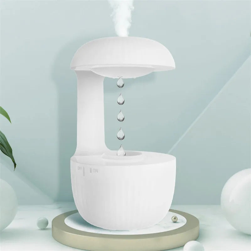 White anti-gravity humidifier showing water droplets levitating upwards from its mist outlet.