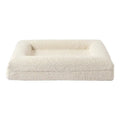 Beige rectangular cloth dog bed nest with raised sides, shown in medium size on a wooden floor.