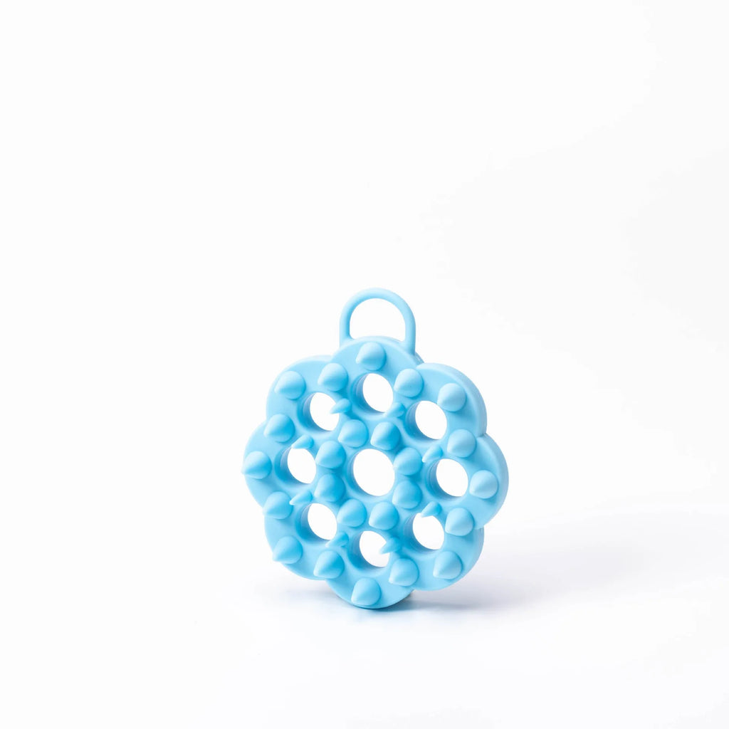 Handheld silicone pet grooming brush for wet and dry use, shown in assorted colours.