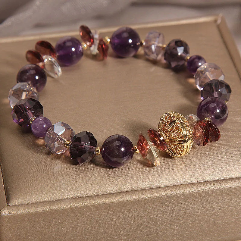 Purple crystal bracelet with pumpkin beads and rhinestone decoration on a wrist.