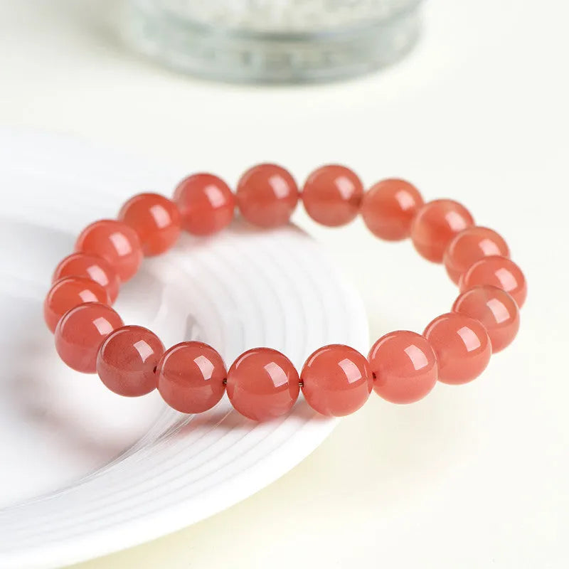 Natural cherry red agate beaded bracelet with high-polish stones on a wrist, showing single and three-strand style options.