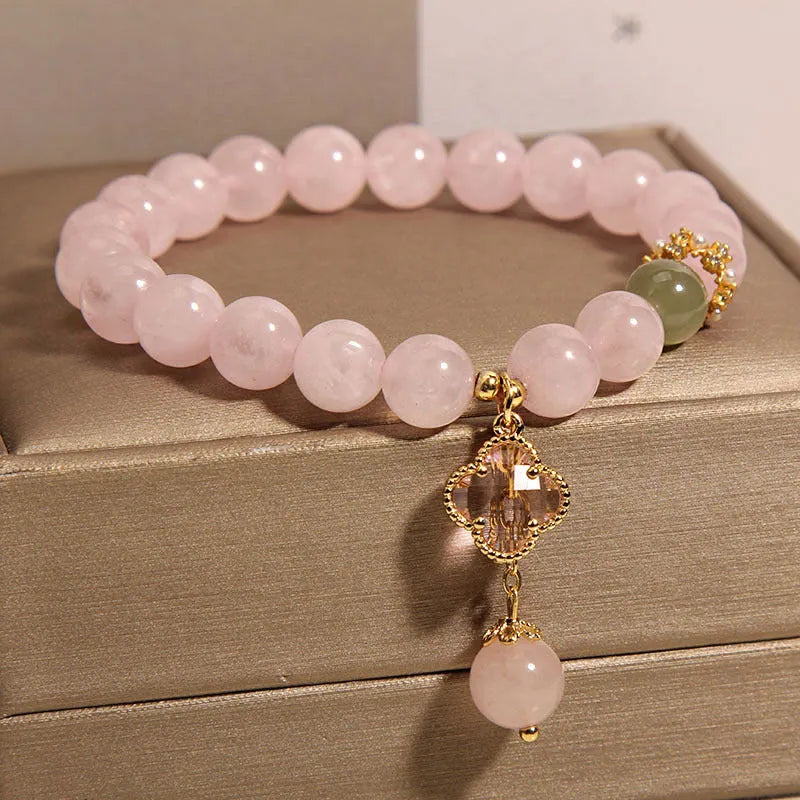 Pink crystal women's bracelet with four-leaf clover pendant charm and rhinestone decoration.