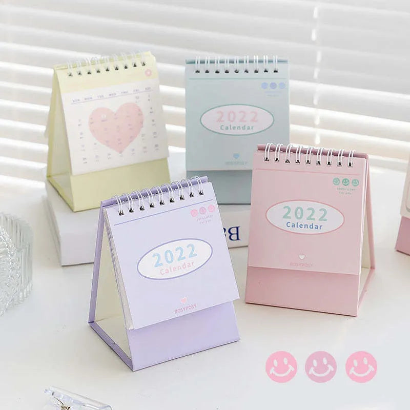 Cream coil desk calendar on a table, regular size 100mm, paper material with year-round date layout