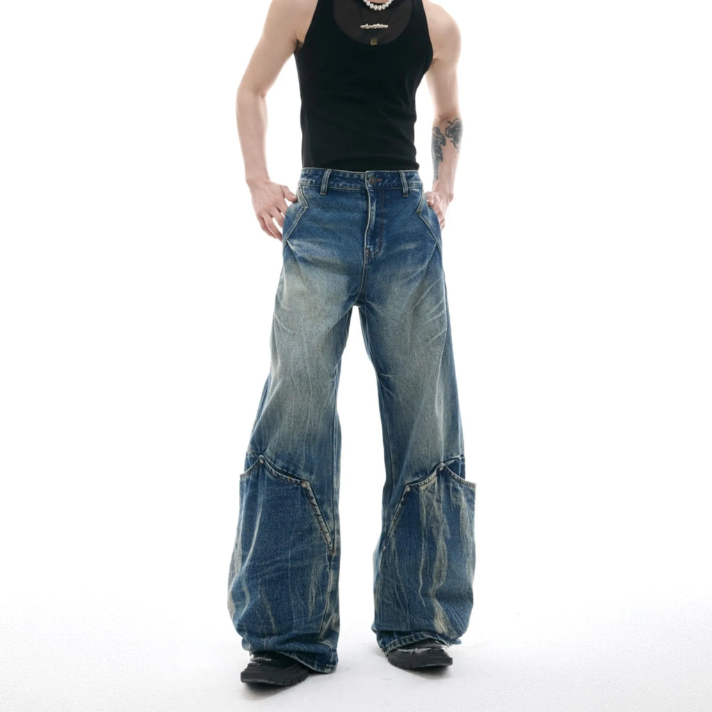 Men's verdant blue loose fit jeans showing curved knife pattern detail and vintage wash on a cotton blend fabric.