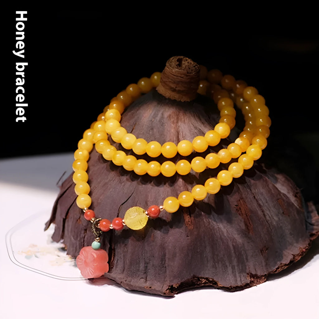 Yellow amber chicken grease beeswax bracelet with 5mm beads and Zodiac modelling on a wrist.