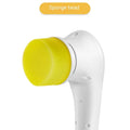 White cordless electric handheld scrubber with five attached brush heads on a table next to a USB charging cable.