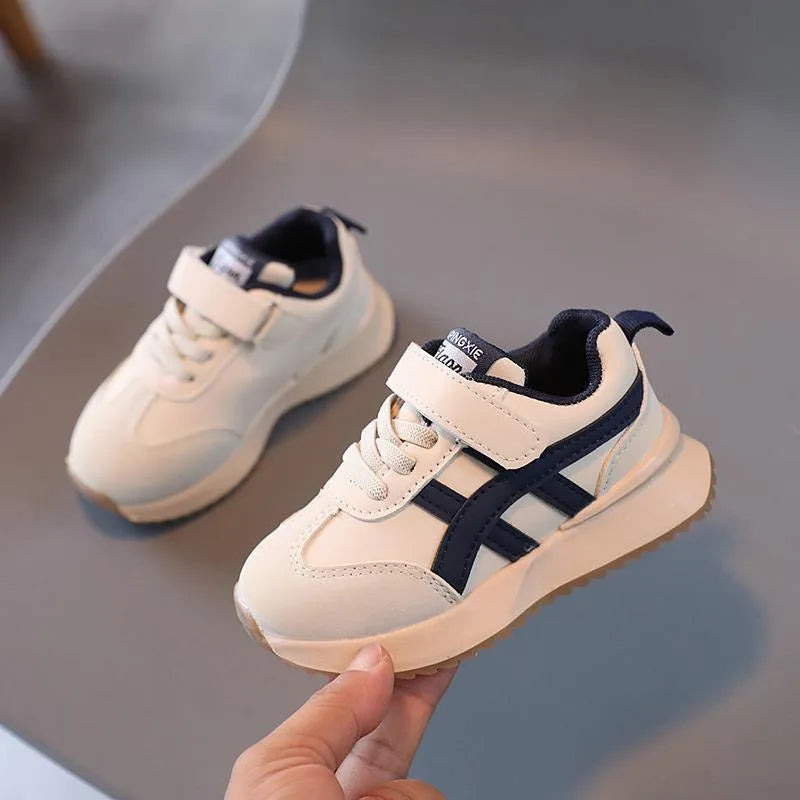 Children's solid-colour Velcro sneakers in synthetic leather with rubber soles, shown in beige.