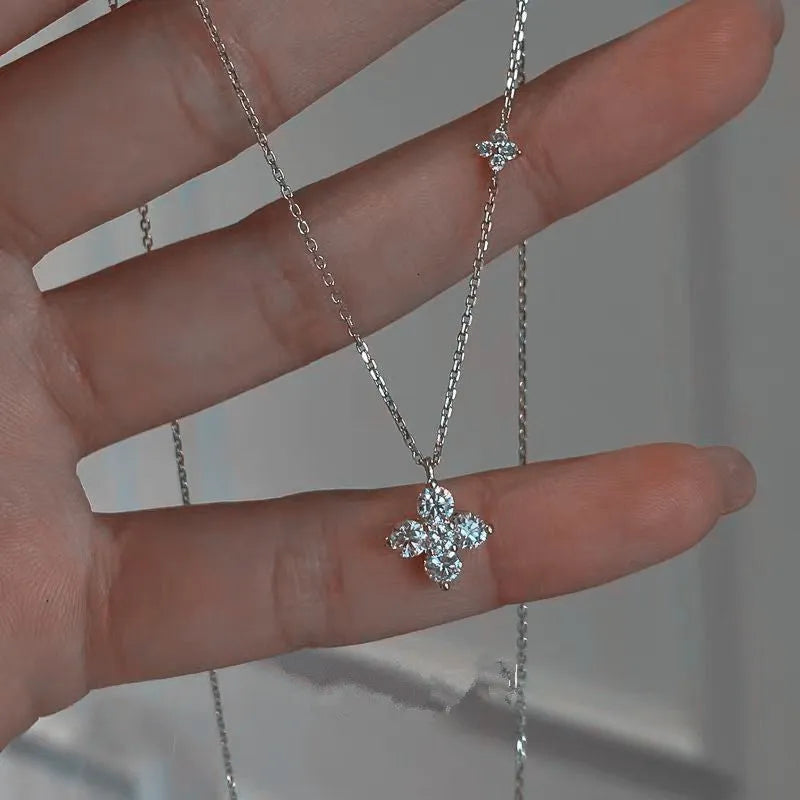 Silver clover clavicle chain necklace with O-ring chain and flower pendant on white background