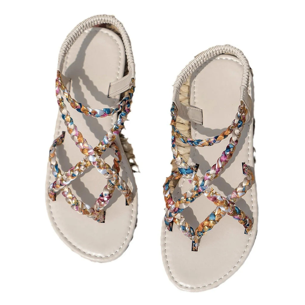 Women's white and black flat sandals with an elastic band across the instep and a round toe.