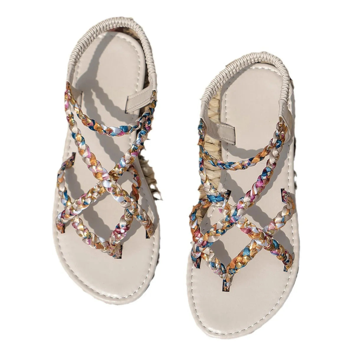 Women's white and black flat sandals with an elastic band across the instep and a round toe.