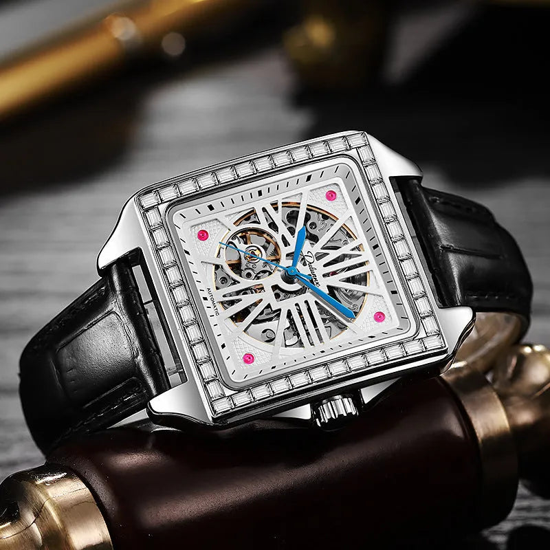 Men's square automatic watch with diamond-studded case on a black leather strap.