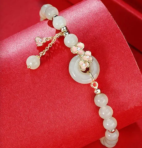 Peach blossom Hetian jade bracelet and necklace set with flower-shaped beads in sterling silver setting
