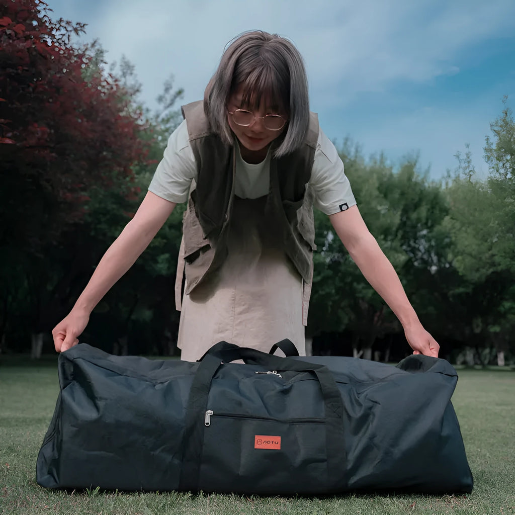 Green oversized waterproof storage bag for camping tables and chairs, shown folded and expanded.